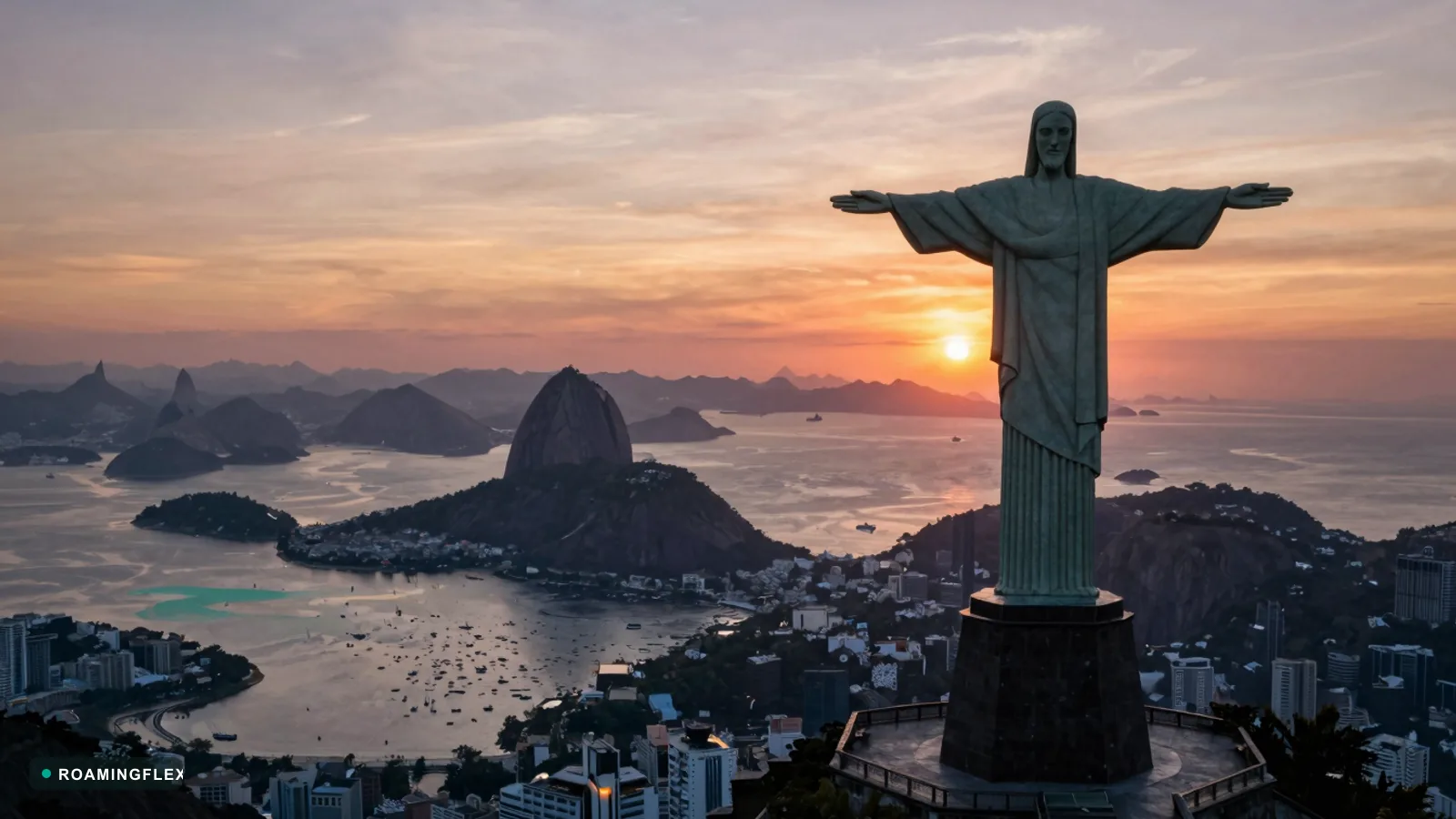 Christ the Redeemer overlooking Rio de Janeiro and Sugarloaf Mountain at sunset, Brazil
