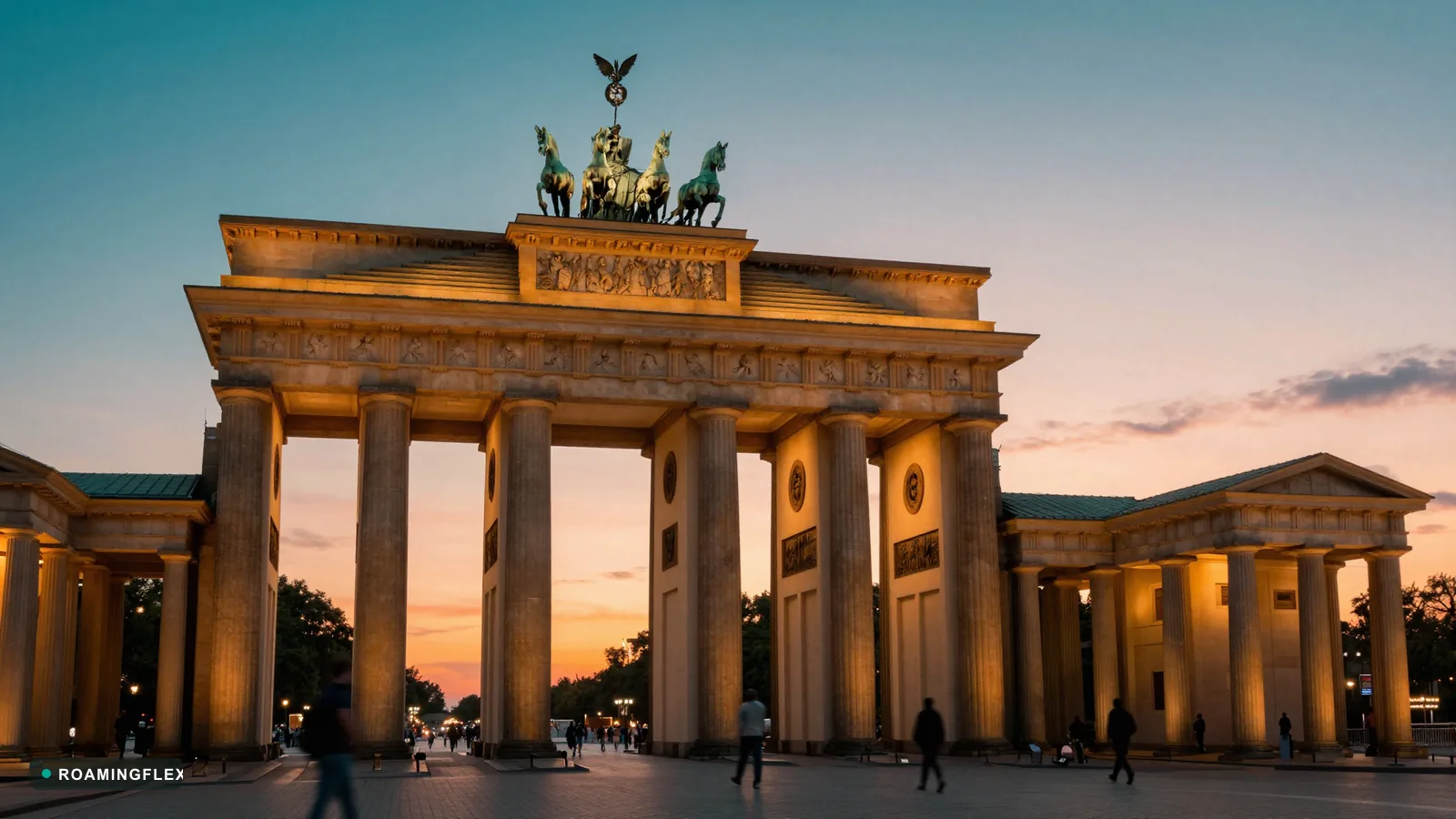 Brandenburg Gate at sunset in Berlin, Germany with people walking past