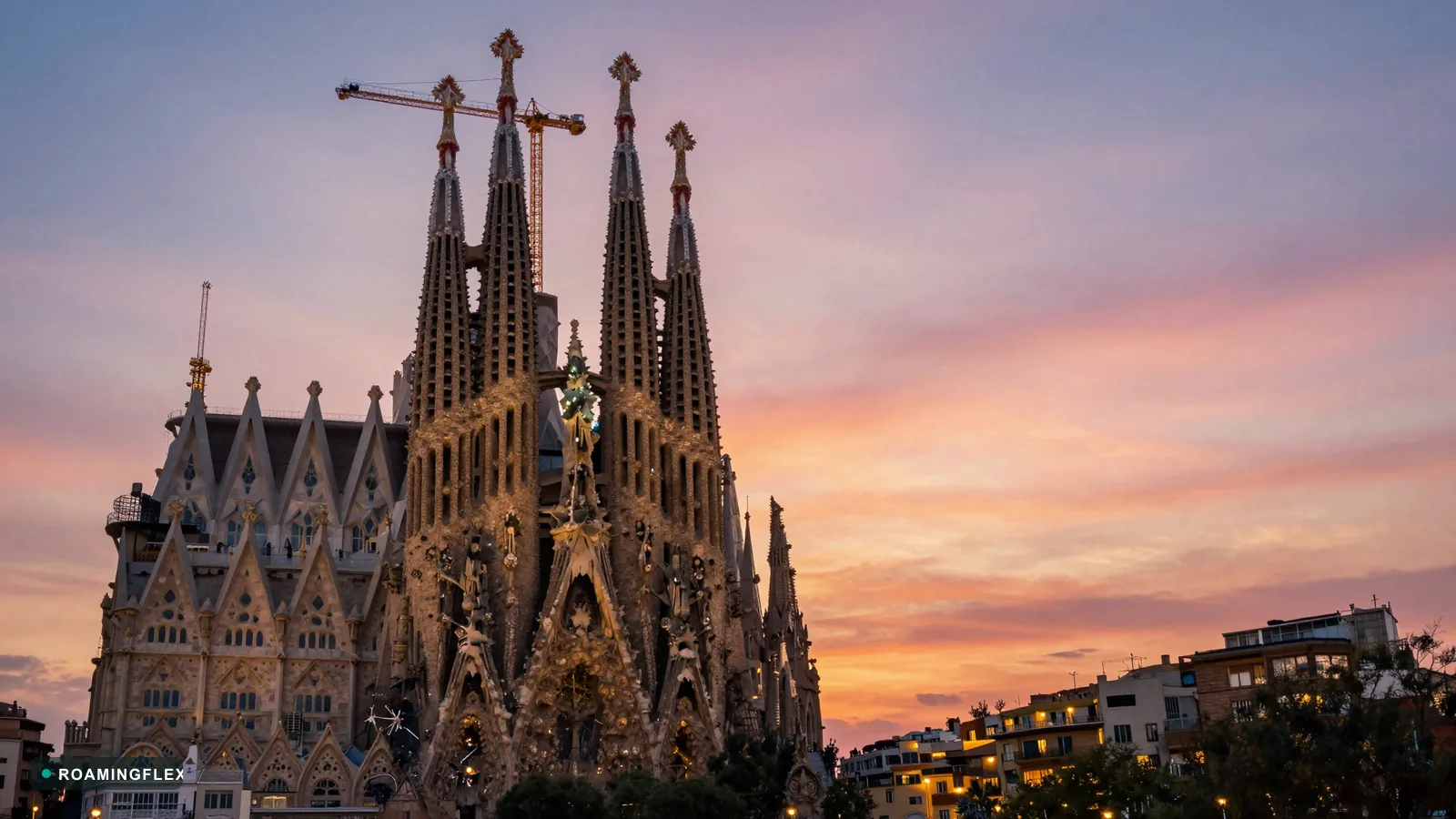Sagrada Familia at sunset in Barcelona, Spain with the city skyline below