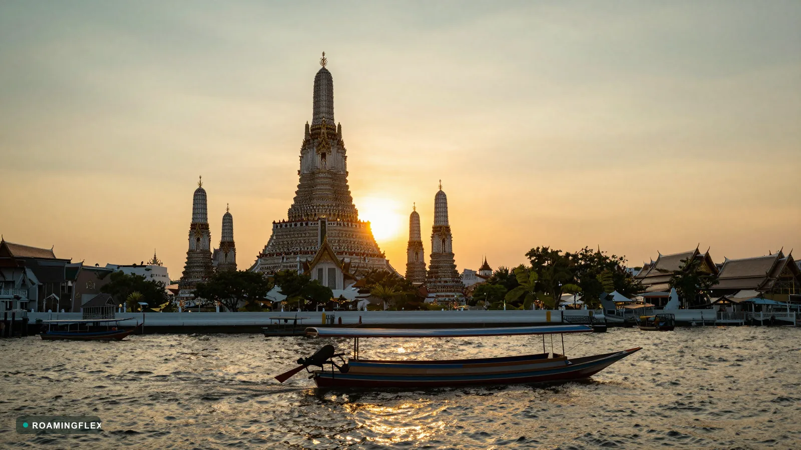 Wat Arun temple silhouette at sunset along the Chao Phraya river in Bangkok, Thailand